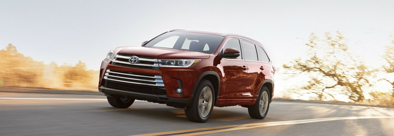 The 2018 Toyota Hylander Hybrid driving down a road