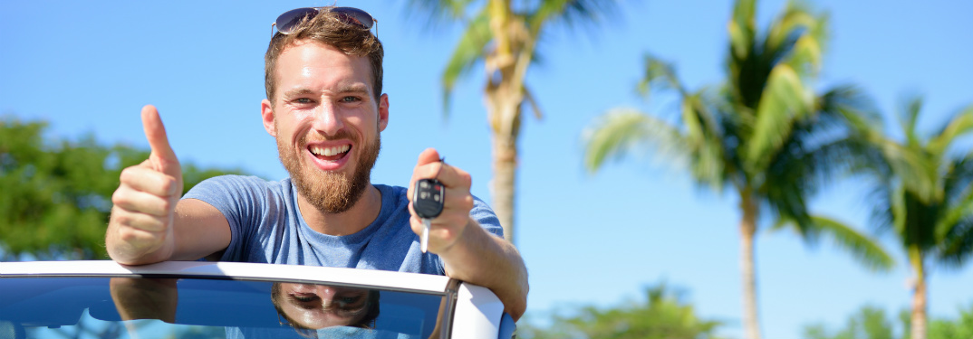 Man holding car keys and giving a thumbs up