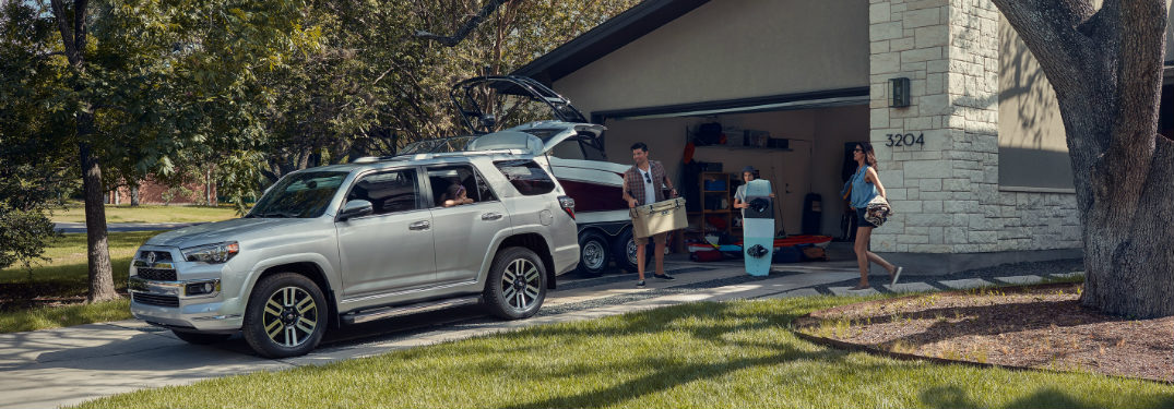 Family loading a cooler and wakeboard into the back of a 2019 Toyota 4Runner