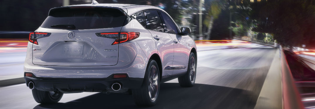 2019 Acura RDX Pricing and Mileage Information with an image of a 2019 Acura RDX with Advance Package in Lunar Silver Metallic driving down a road in a city at night