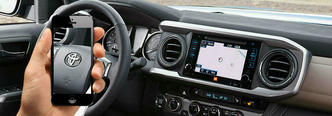 Person holding smartphone with screen that shows a Toyota Steering wheel that matches with the overall interior of a Toyota model