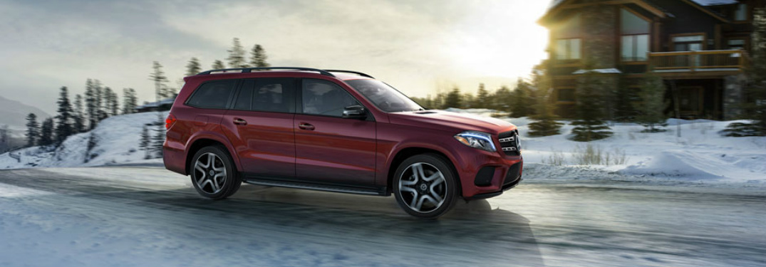 Red 2018 Mercedes-Benz GLS driving by house in snow