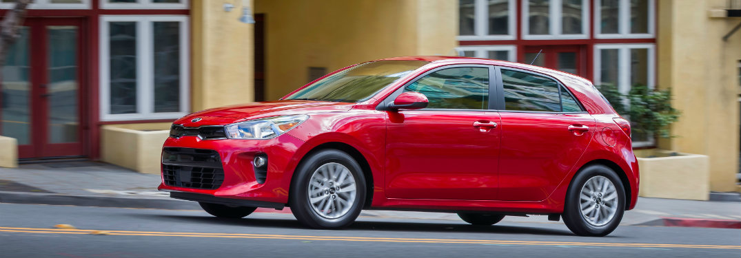 left side of red kia rio hatchback
