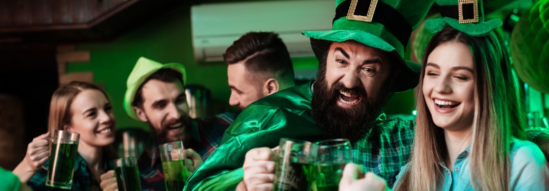 Friends having fun in a tavern wearing green clothes during St. Patrick's Day.