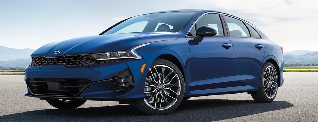 The front and side view of a blue 2021 Kia K5.