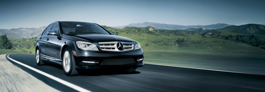 Black Mercedes-Benz vehicle driving along open road