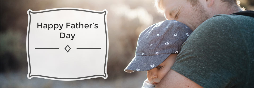 Father holding son with "Happy Father's Day" written to left of frame