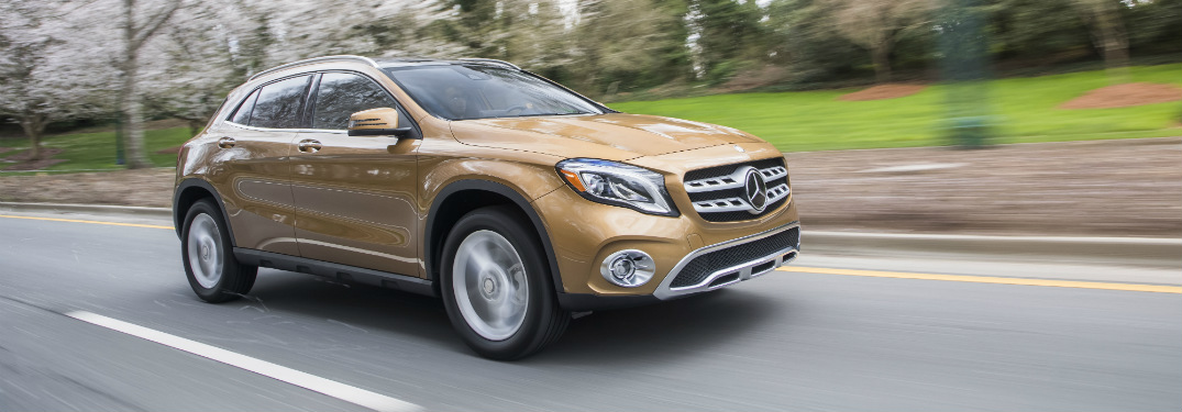 bronze 2018 mercedes-benz gla 250 suv driving on road past trees