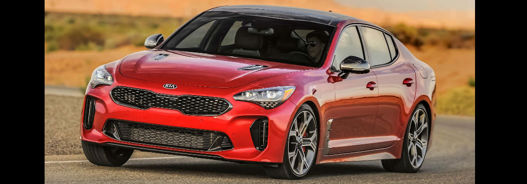 a red 2018 Kia Stringer driving on the track, seen mostly from the side