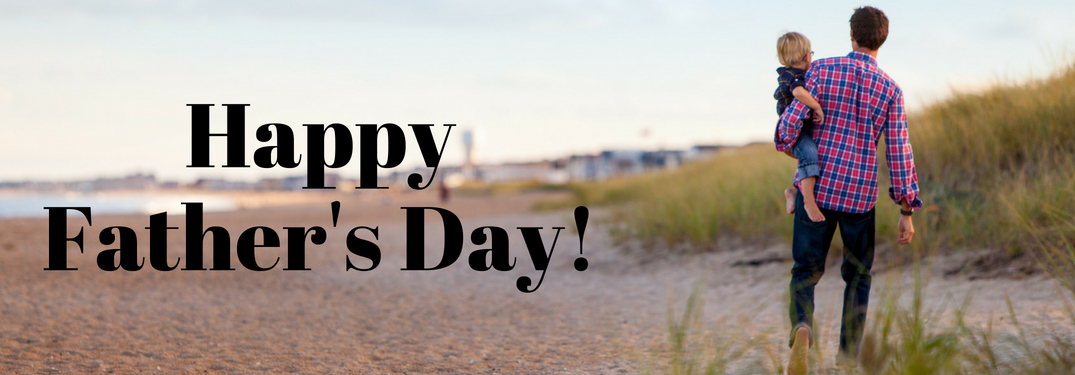 Happy Father's day written over the image of a father carrying a small child on a beach