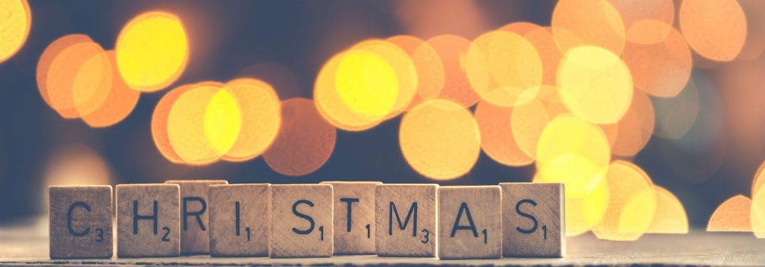 christmas spelled out with scrabble letter with blurred lights background