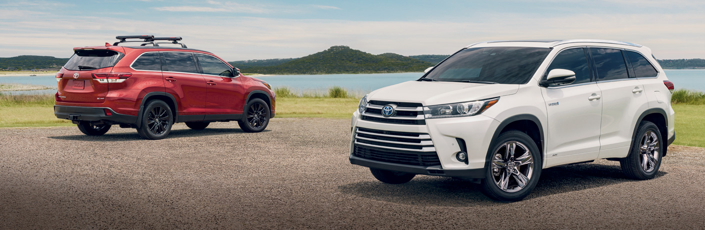 two toyota highlander vehicles parked by a lake
