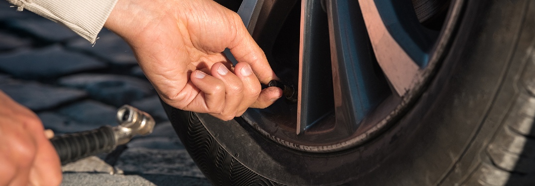 person inflating tire on vehicle
