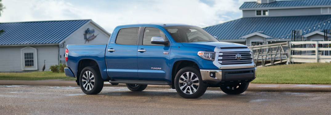 Blue 2018 Toyota Tundra parked in front of blue and white buildings