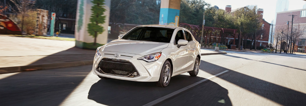 White 2019 Toyota Yaris driving under structure