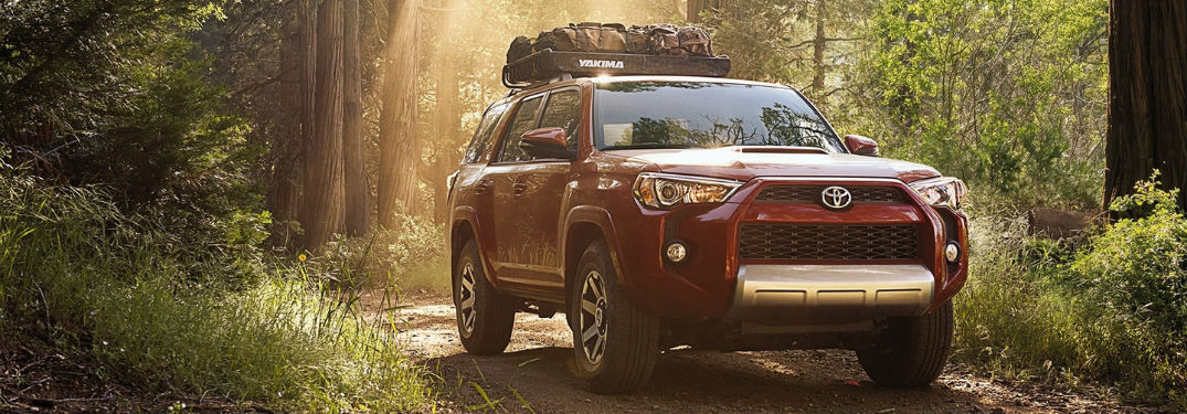 Red 2018 Toyota 4Runner driving off-road through forest