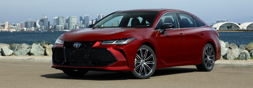 Red 2019 Toyota Avalon parked in front of city skyline