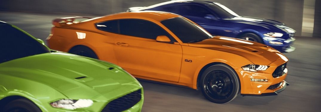 2020 Ford Mustangs driving together on road