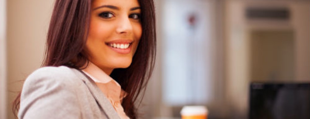 a happy woman smiling at her desk