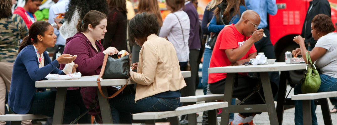 A stock photo of people eating outdoors.