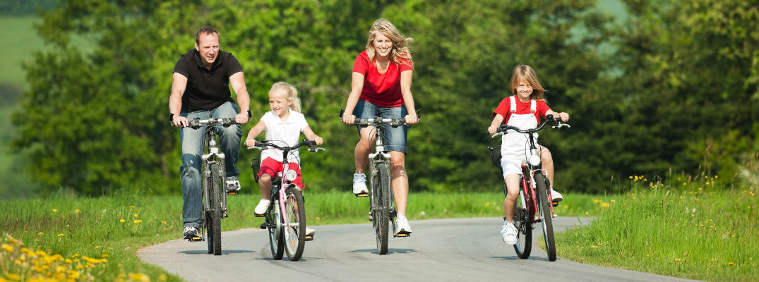 A stock photo of a family riding their bikes on a trail.