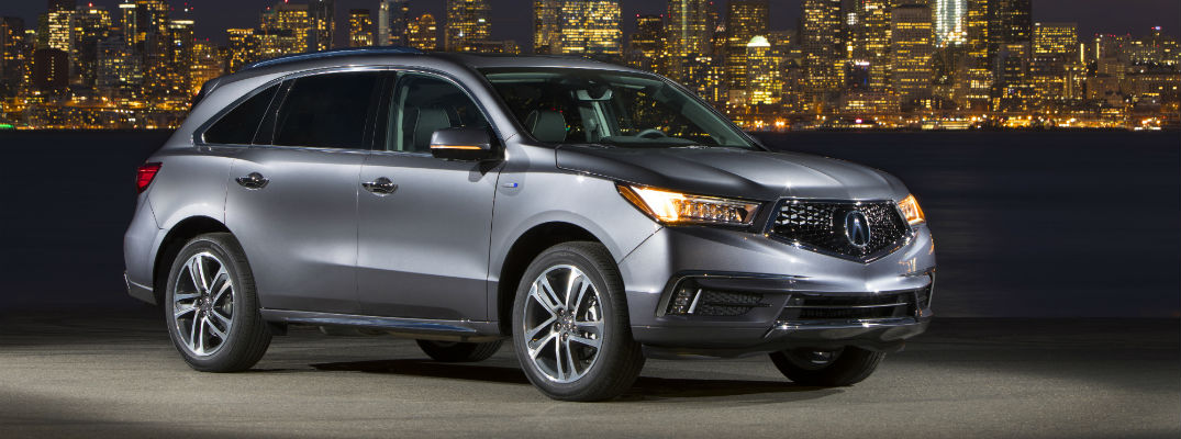 A right profile photo of the 2019 Acura MDX Sport Hybrid in front of a city skyline.