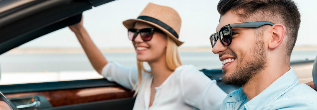 Couple driving in a convertible with the top down