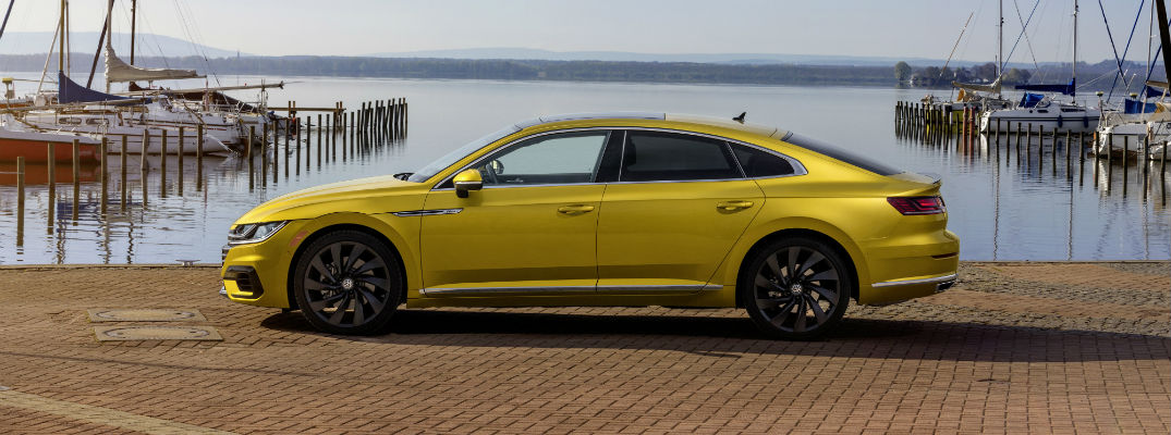 A left profile photo of the 2019 VW Arteon in front of a harbor.