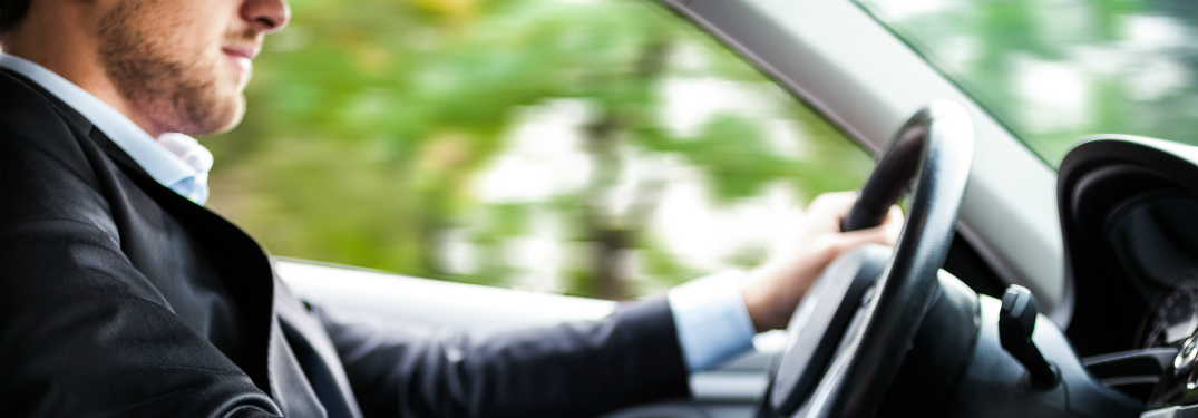 man in suit driving a car