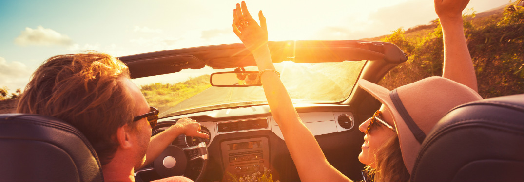 man and woman driving into the sunset