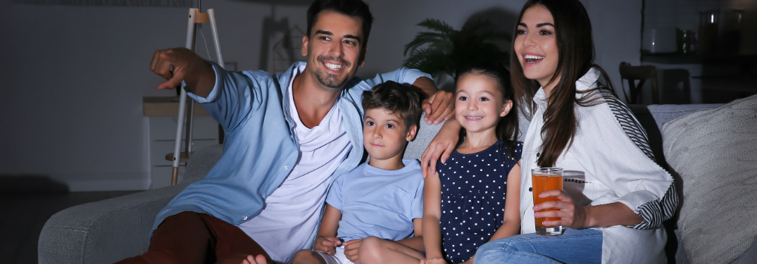 Family of four watching a movie on their couch