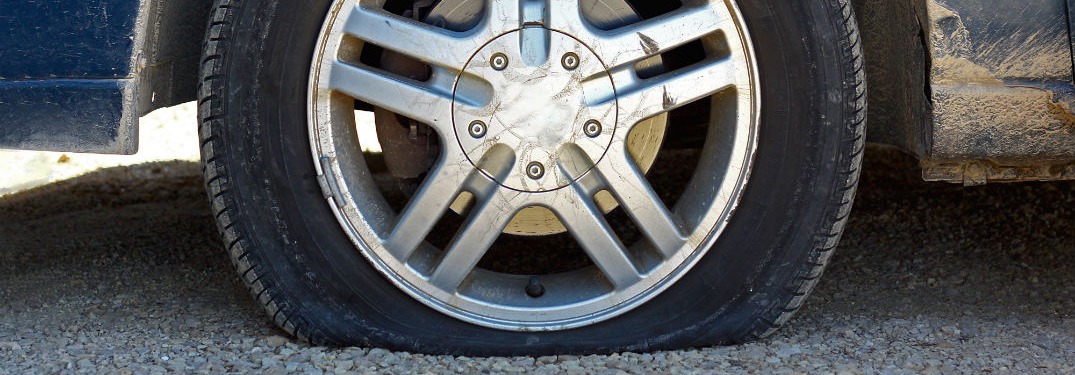 car without flat tire on asphalt road