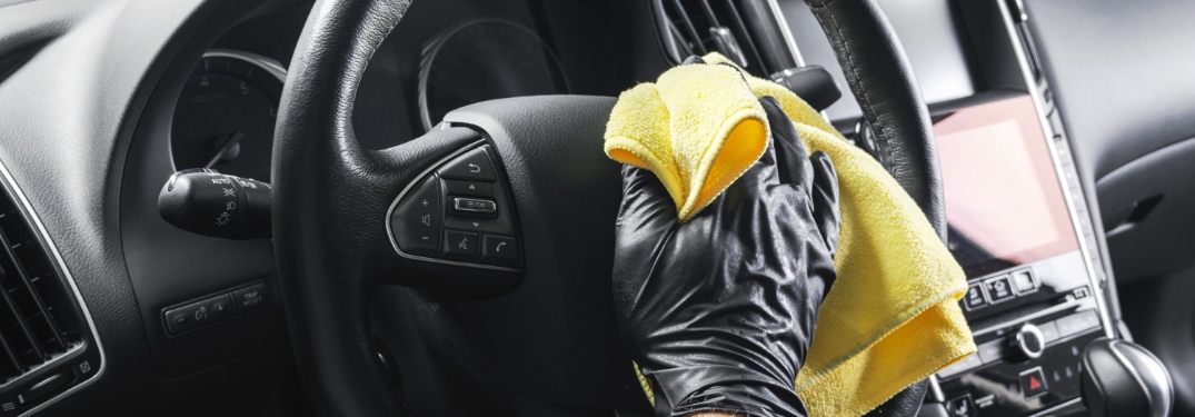 person cleaning a steering wheel