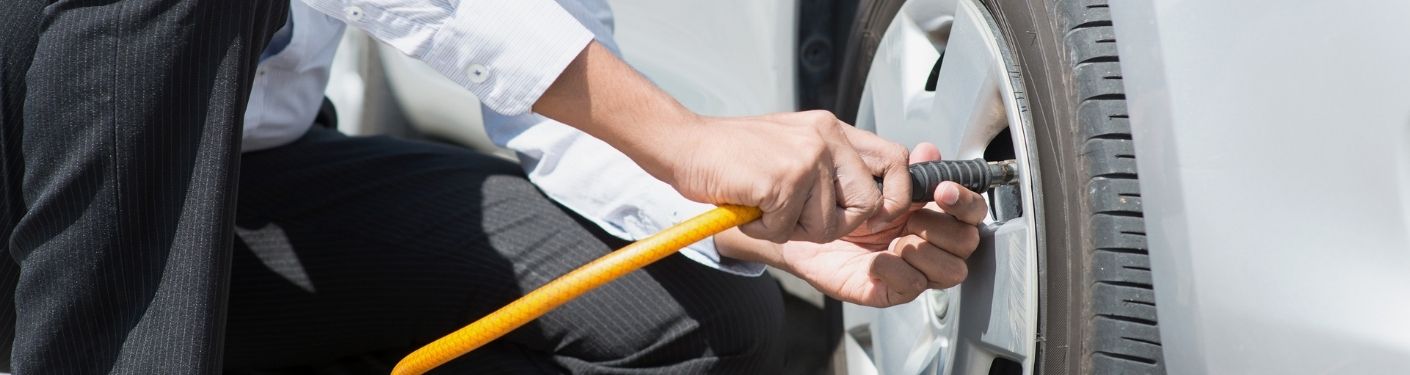 driver checking car tire pressure