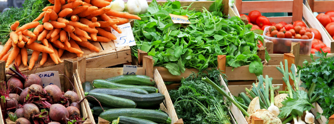 Rows of veggies in crates on display at the farmers market