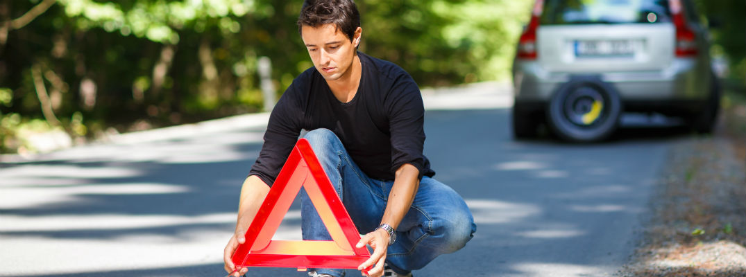 Man putting triangle reflector in road