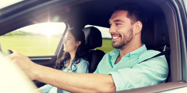 Man smiling in front seat of car