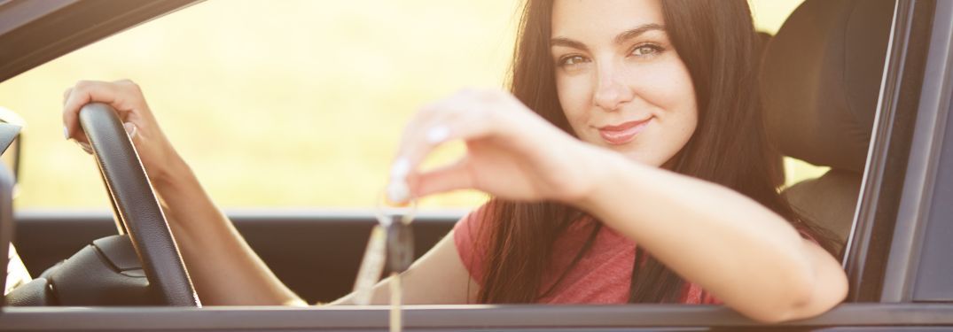 Woman sitting in car holding car key