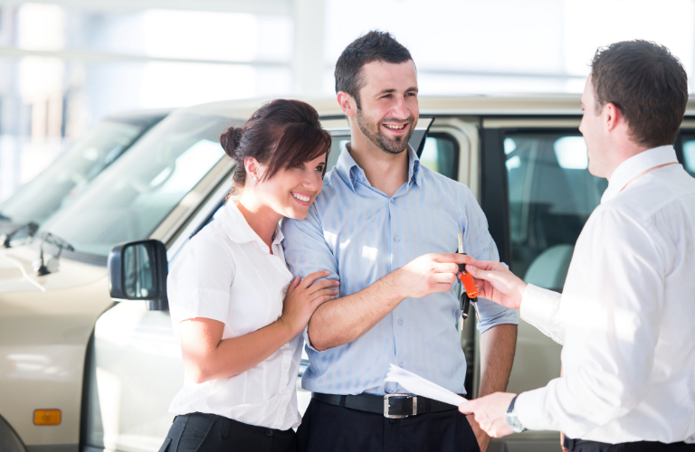 Couple taking keys at the dealership 