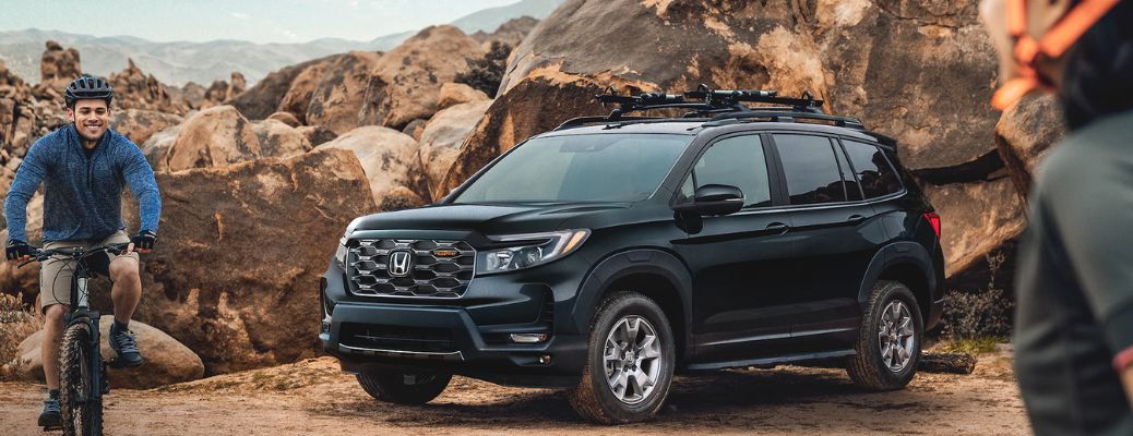 Front quarter view of the 2023 Honda Passport with a cyclist in the background