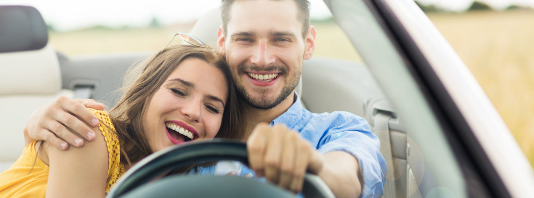Couple driving a vehicle while on vacation