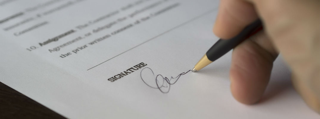 A stock photo of a person signing a document.