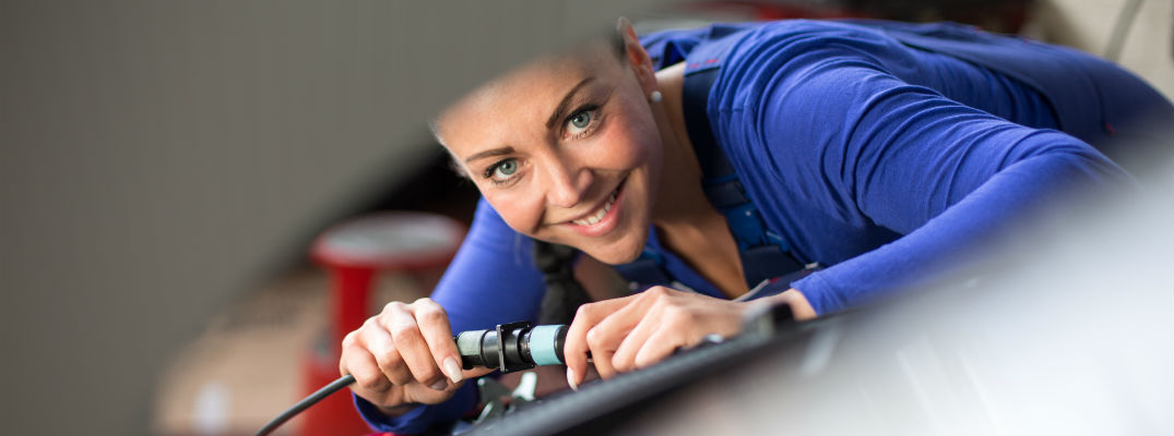 A stock photo of a service technician working on a vehicle.