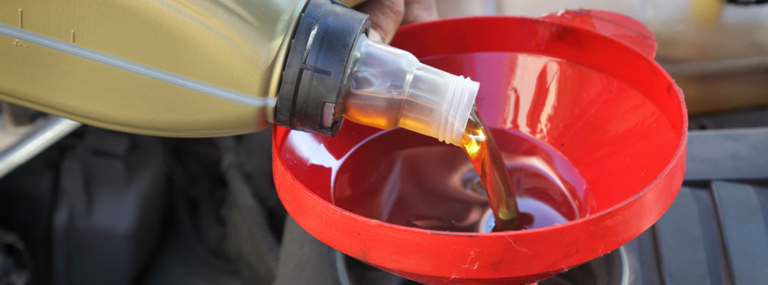 A stock photo of oil being poured into an engine.
