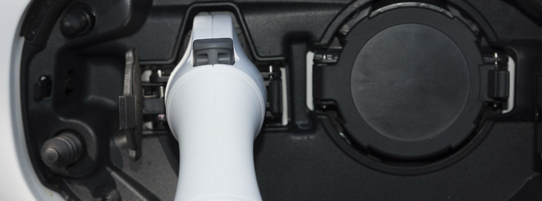 A photo of a Mitsubishi Outlander PHEV with the electric charging port being used.