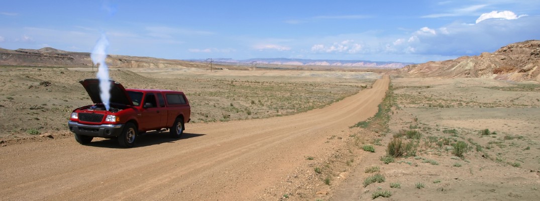 A SUV on the side of the road with the hood open