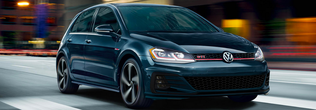 2020 Volkswagen Golf GTI driving down a city street at night