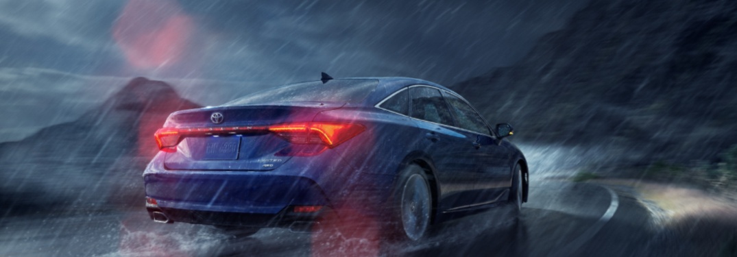 2021 Toyota Avalon driving down a rural road during a storm