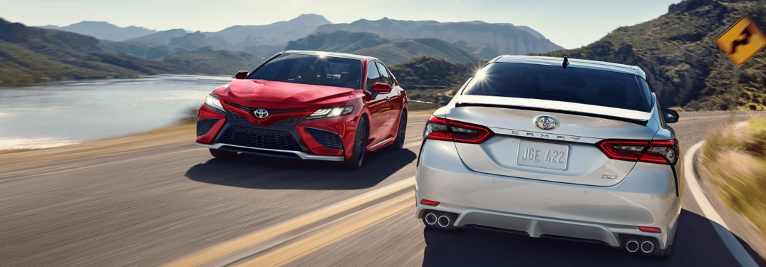 Two 2021 Toyota Camry models passing by one another on a road