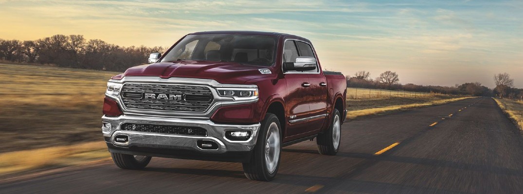 2020 Ram 1500 dark red paint driving on country road toward shot at sunset showing front bumper and driver side doors